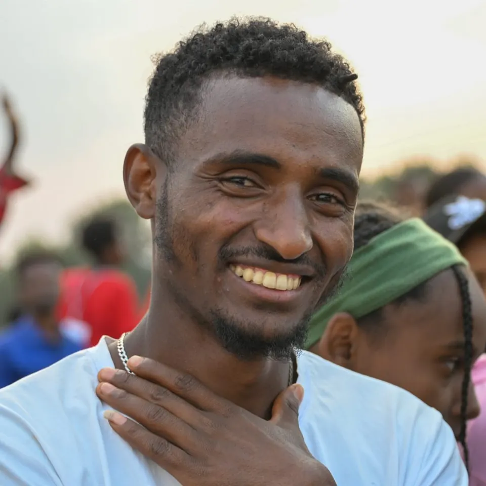 Man smiling at an In His Name Ministries gathering